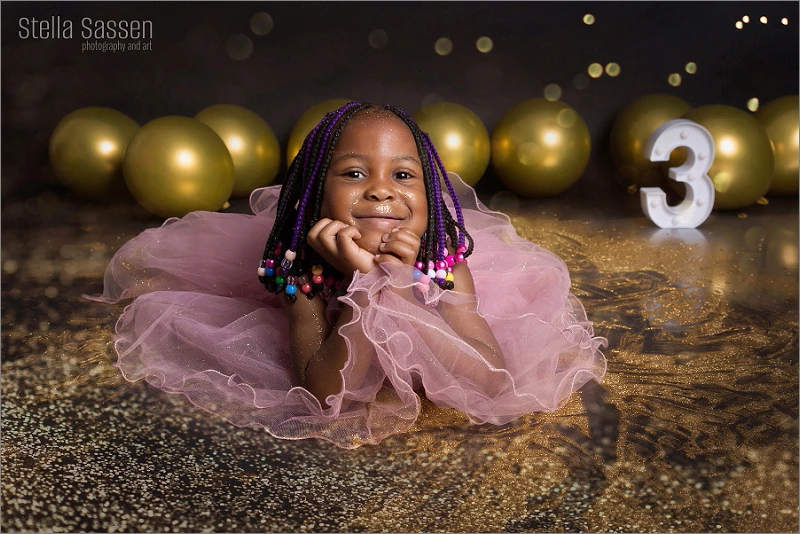 Little girl glitter shoot with balloons and gold glitter